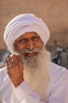 AN OLD MAN WITH TURBAN HAPPILY POSING FOR CAMERA	