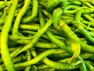 Long hot chili peppers on the market. Green spicy vegetables on the market or harvest festival. Overhead view