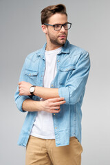 Portrait of young handsome caucasian man in jeans shirt over light background