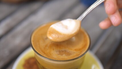 Hands takes of the froth of cappuccino coffee