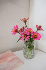 Bouquet of pink Zinnia flowers from garden in a glass vase.