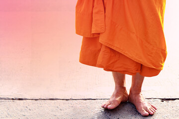 The feet and legs of a monk standing barefoot