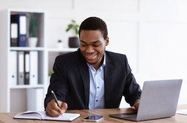 Smiling african american entrepreneur having online training in office