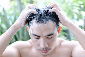 Young man serious hair loss problem for health care medical and shampoo product with green nature, selective focus