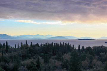 winter purple panoramic view of corfu town island mountains and sea with cypress and olive trees