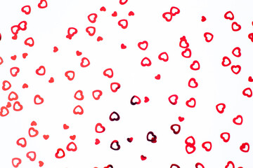 Valentine's Day background February 14th. Red hearts confetti on white background. Valentines day creative concept. Flat lay, top view, copy space.