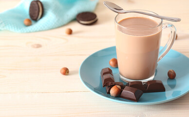 Cup of cocoa and nuts on a white wooden background with place for text