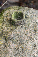 Old clay pot on rock with moss