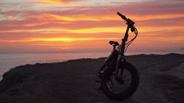 Amazing colorful sunset and an electric bicycle in the foreground, Half Moon Bay California.