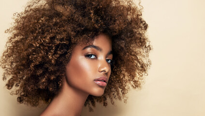 Beauty portrait of african american girl with clean healthy skin on beige background. Serious beautiful black woman.Curly hair in afro style
 - Powered by Adobe