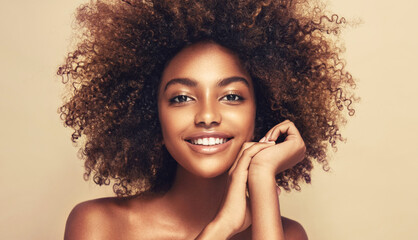 Beauty portrait of african american woman with clean healthy skin on beige background. Smiling...