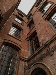 Fototapeta na wymiar Upward view to high building red brick wall with big windows