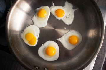Five quail eggs on professional pan.