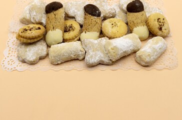 Bosnian Tea cookies of varied shapes and colors on a creamy background