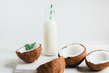 coconuts and coconut milk in a bottle on a white background