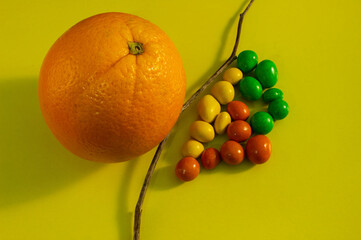 peanut dragees on a yellow background. the idea of confronting healthy and unhealthy food