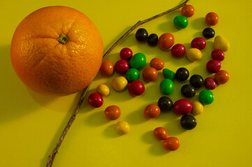 peanut dragees on a yellow background. the idea of confronting healthy and unhealthy food