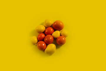 Summer trendy trendy sunlight pattern with yellow and orange peanut dragees on a yellow background 