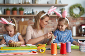 Bobbins of colored thread and women doing easter decoration