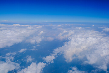 Blue sky background with tiny clouds from airplane