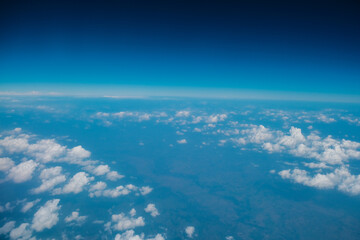 Fototapeta na wymiar Blue sky background with tiny clouds from airplane