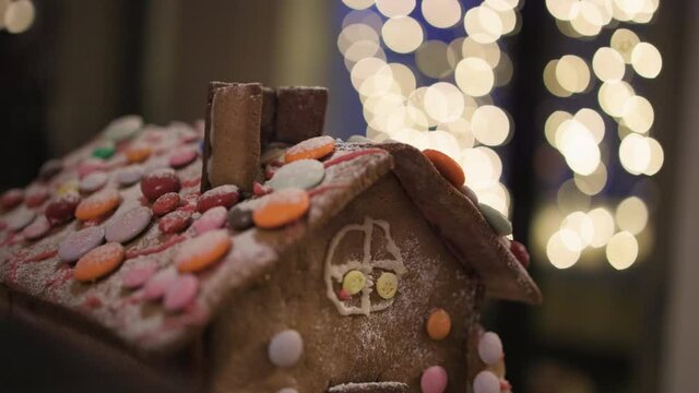 Close-up pan of upper half of gingerbread house with smarties on roof