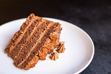 piece of chocolate cake brown cream sweet dessert on a white plate ready to eat on the table for healthy meal snack top view copy space for text food background rustic image