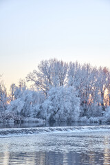 Dramatic winter sunset with the view of a river and everything frozen by the cold
