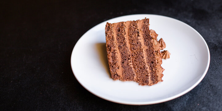 piece of chocolate cake brown cream sweet dessert on a white plate ready to eat on the table for healthy meal snack top view copy space for text food background rustic image