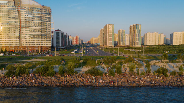 Saint-Petersburg. The beach near the new buildings of the Parusa residential complex. People relax on the beach.