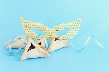 Purim celebration concept (jewish carnival holiday) over pastel blue background