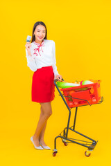 Portrait beautiful young asian woman with grocery basket from supermarket