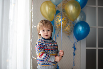 Fototapeta na wymiar Kid with a bunch of blue and gold balls