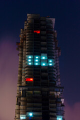 Night view to skyscraper building still under construction and beautifully illuminated. Shot at blue hour in JBR, Dubai.
