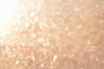 Glitter abstract background with unfocused soft golden light. Defocused image.