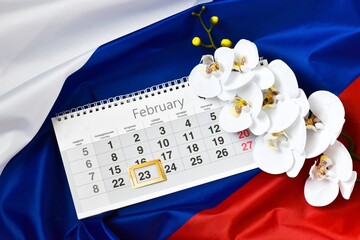 Russian flag, flower orchid and calendar with framed date 23 February. Defender of the Fatherland...