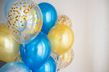 Blue and transparent balloons with golden confetti on zigzag wallpaper background