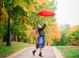 Young attractive smiling girl under umbrella in autumn forest