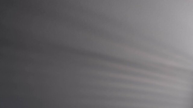 Blurry dark shadows moving on the wall. Spooky shadow art noise texture. closeup the motion of shadow batten of lath light on white wall texture background. Slow motion video. stock footage