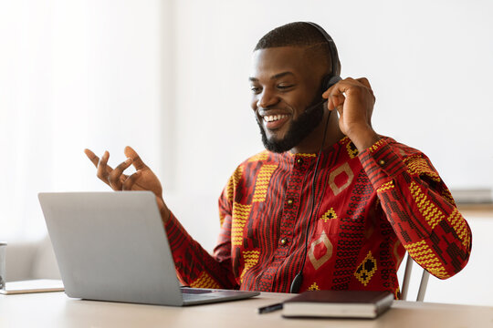 Black Man In African Shirt Making Video Call With Laptop And Headset