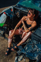 Fototapeta na wymiar Dump, portrait of a woman in a broken car, glasses, accident, summer, heat