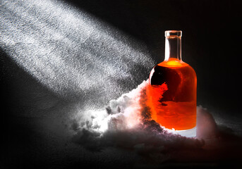A vessel, a bottle with a liquid of dark brown color with light refractions and glare in the snow