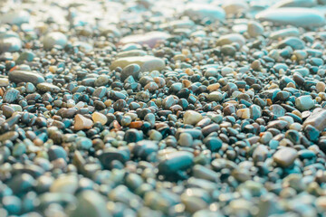 A natural background of wet stone against the background of the blue seashore.