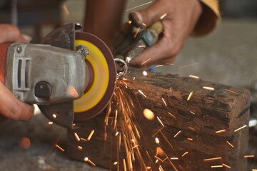 Man's Hand Smooths The Hinges Using A Grinding Machine