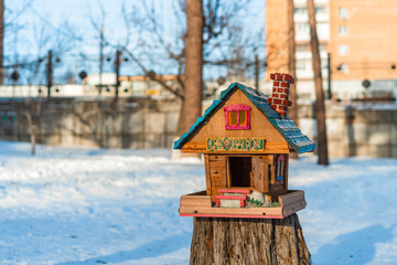 Obraz na płótnie Canvas Togliatti, Russia - 18 Jan 2021: Wooden feeder in the form of a house in winter, Russian inscriptions