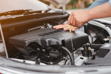 Obraz premium The male mechanic's hand checked the level of engine oil. And engine readiness before departure, concept of engineer and car repair