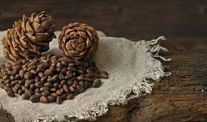 pine nuts lie on a linen cloth, pine nuts lie on an old wooden board on the back side view