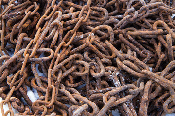 Old rusty metal chains. The chains are in the snow.