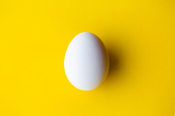 White egg on a yellow background. Egg on a yellow background. White egg with shadow.
Easter concept.
Breakfast food. Ingredient
