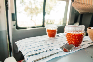 A young woman having breakfast in her caravan observing a good view of the beach